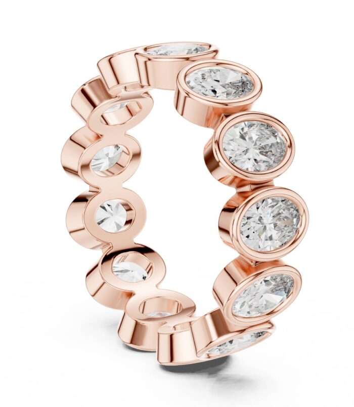 Bezel set oval cut diamond eternity band in rose gold with full bezel settings